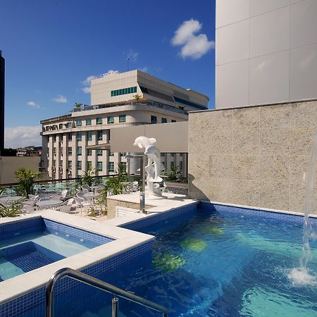 Hotel Atlântico Business Centro Rio de Janeiro Esterno foto The photo shows a rooftop area featuring a swimming pool and a spa. The pool is inviting with a clear blue water, and there appears to be a waterfall feature. Surrounding the pool are areas for relaxation, possibly with sun loungers. In the backgroun